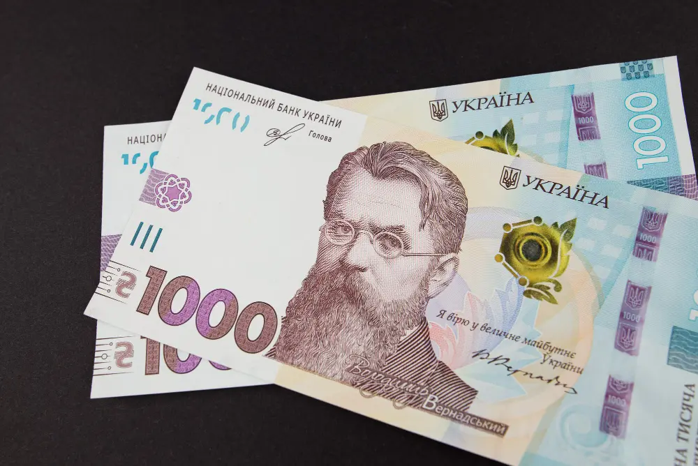 Купюры номиналом 1000 гривен с портретом В. Вернадского на фоне темной поверхности
