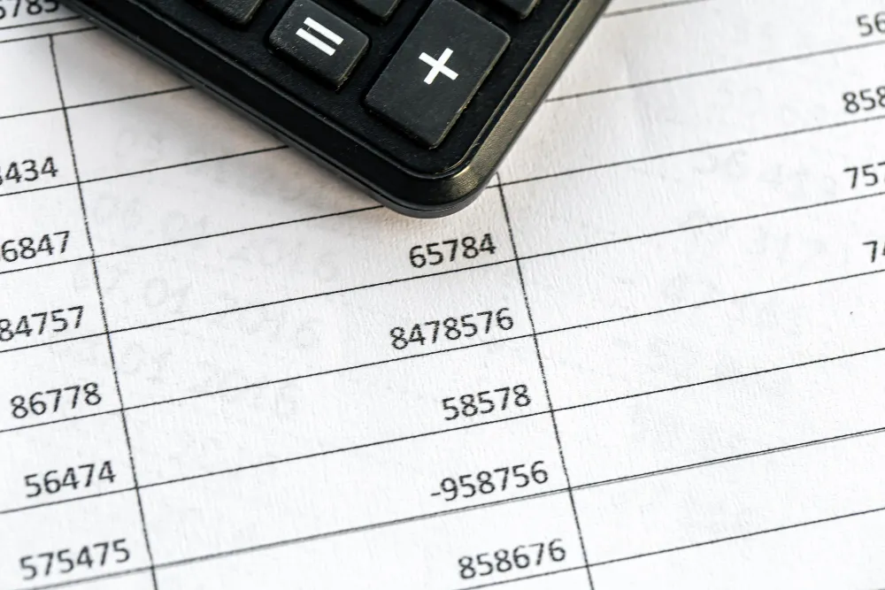 Крупний план калькулятора на фінансових документах: детальний процес підрахунку терміну окупності сонячної станції та економії бюджету за тарифами 2026 року