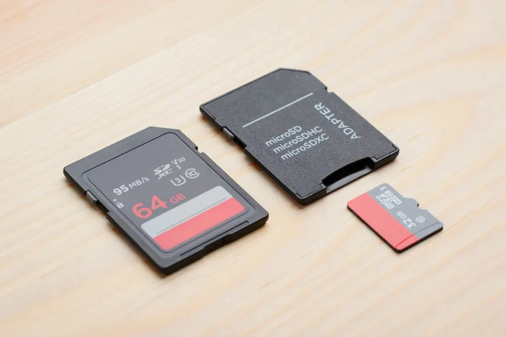 Карта пам’яті SD на 64 ГБ, microSD на 32 ГБ з адаптером на дерев’яній поверхні